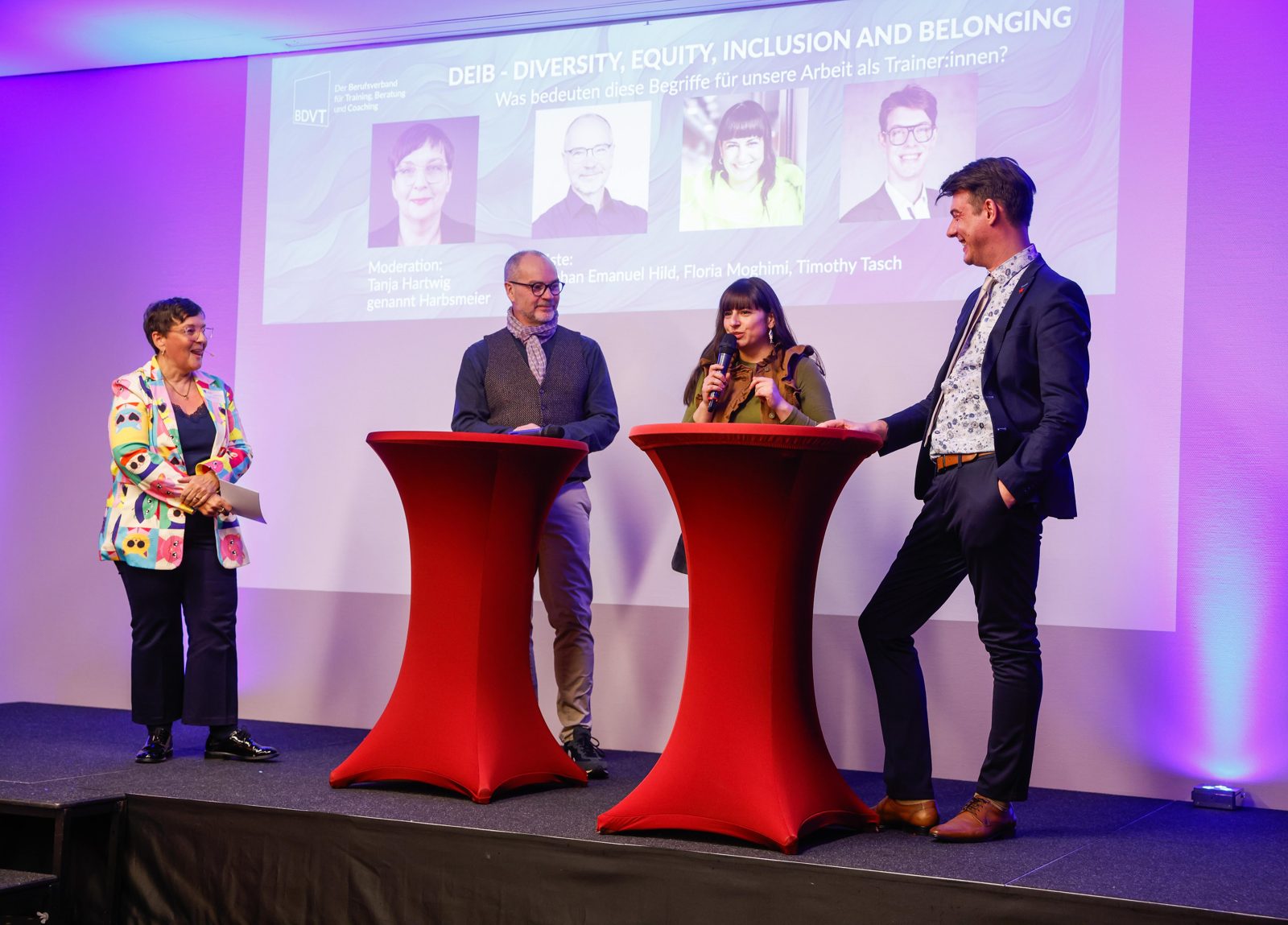 Das gesamte Panel auf der Bühne, im Hintergrund die Titelfolie zu Diversity, Equity, Inclusion and Belonging